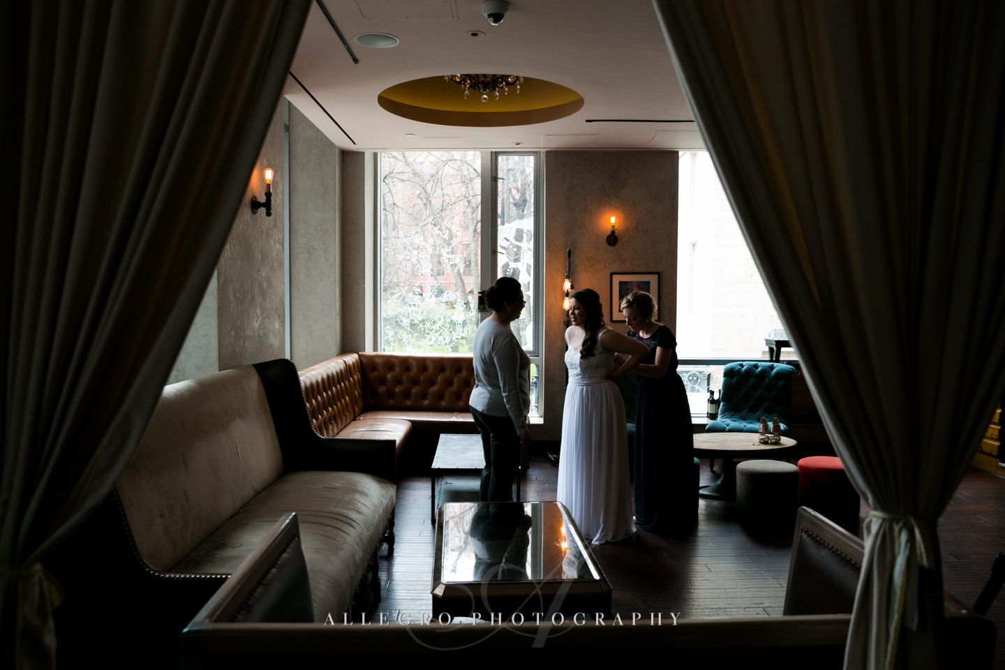 bride puts on dress- hotel nine zero -photo by allegro photography