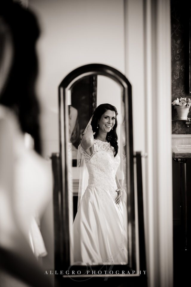 bride checks herself out in mirror - photo by Allegro Photography