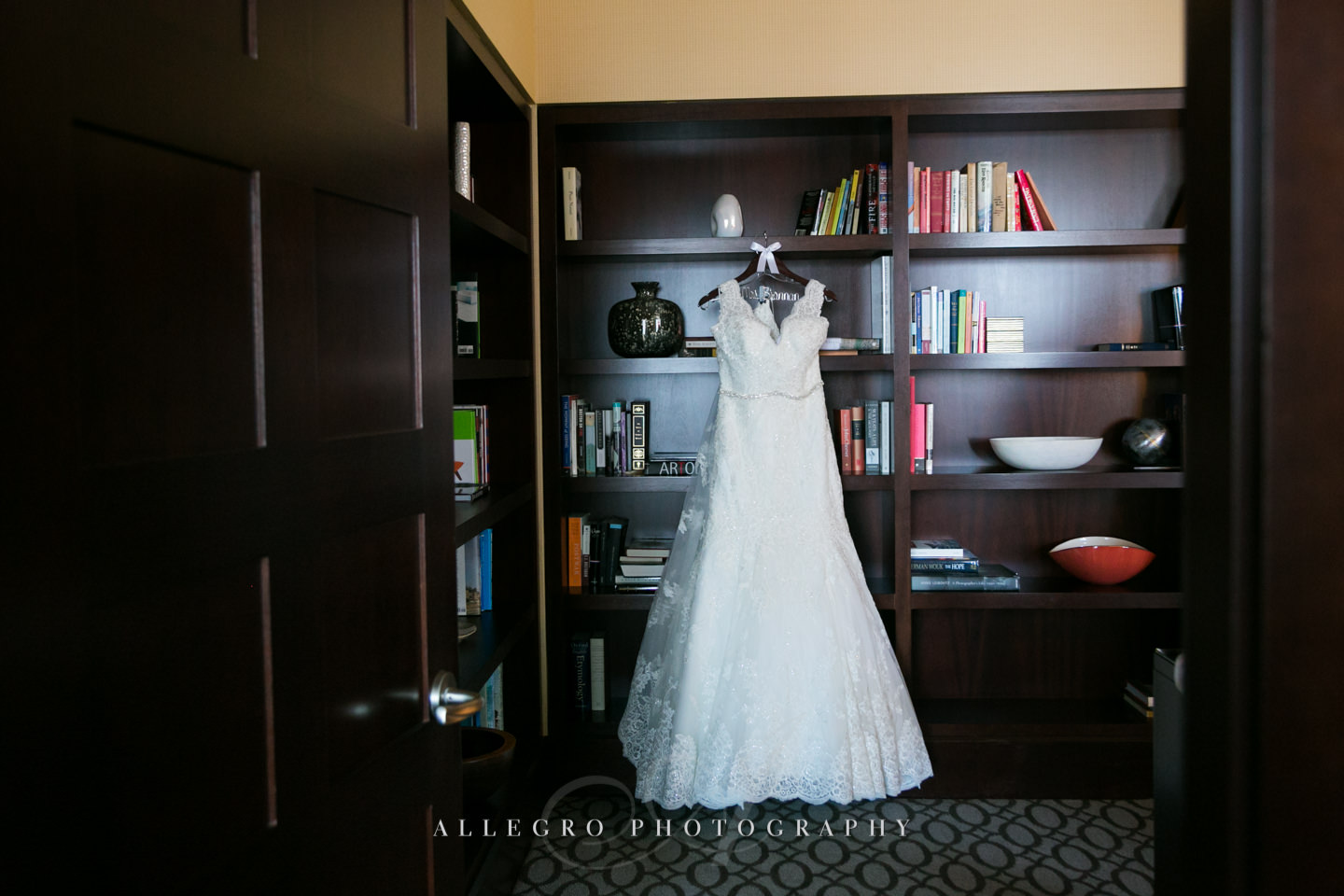 wedding dress hanging on bookshelves