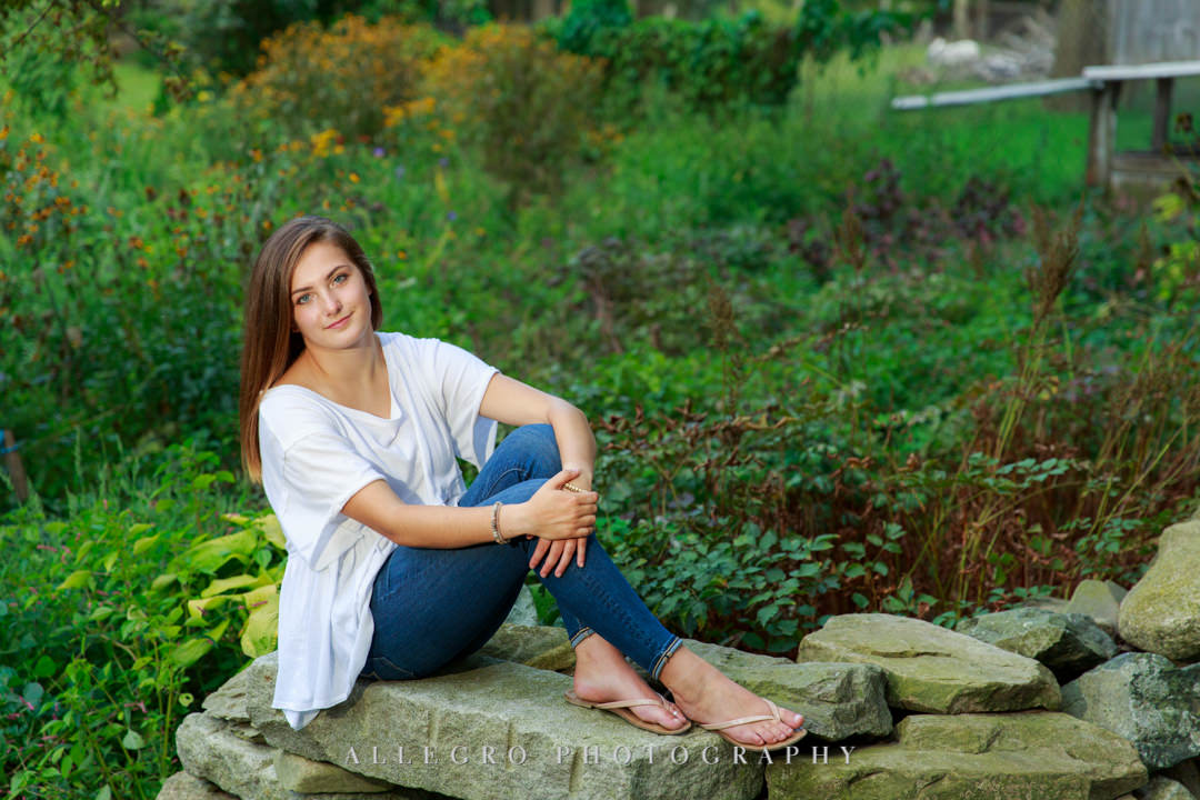 allegro photography senior pics- relaxed on stone wall- young lady