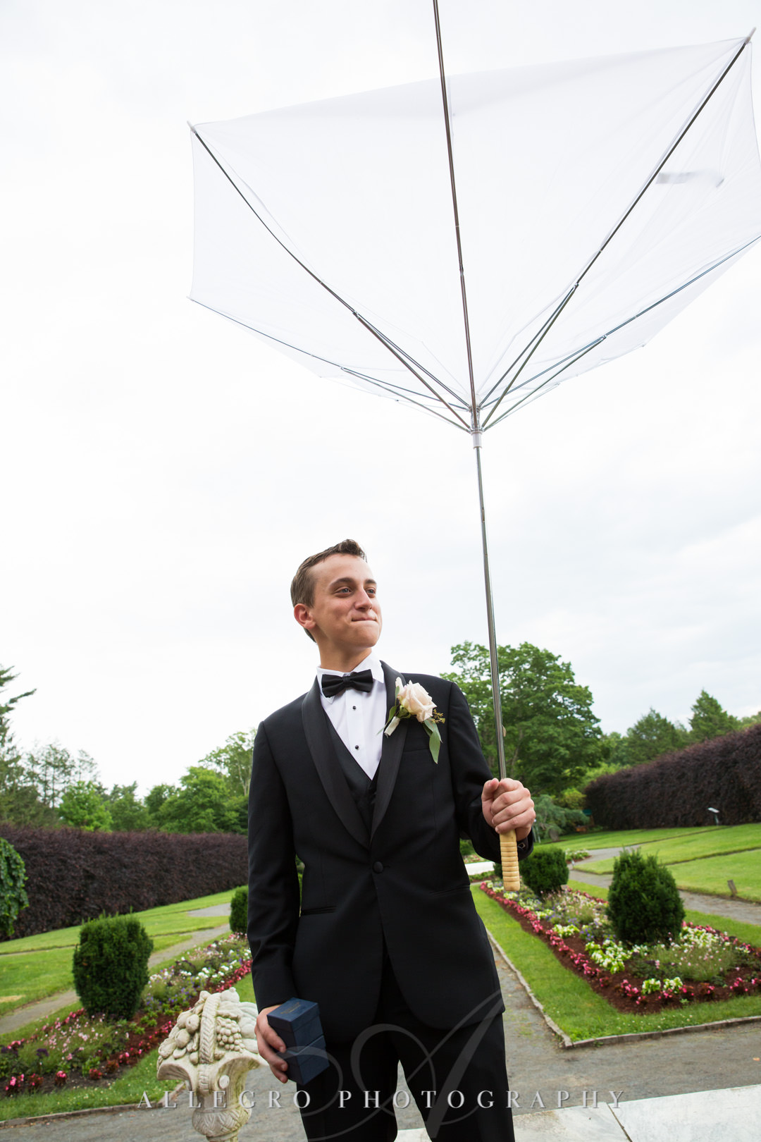 Son of groom holding upside-down umbrella | Allegro Photography