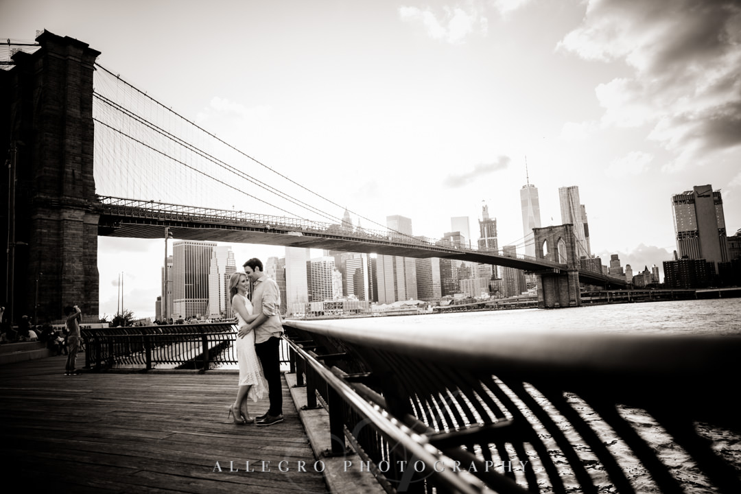 Engaged couple against Brooklyn Bridge skyline | Allegro Photography