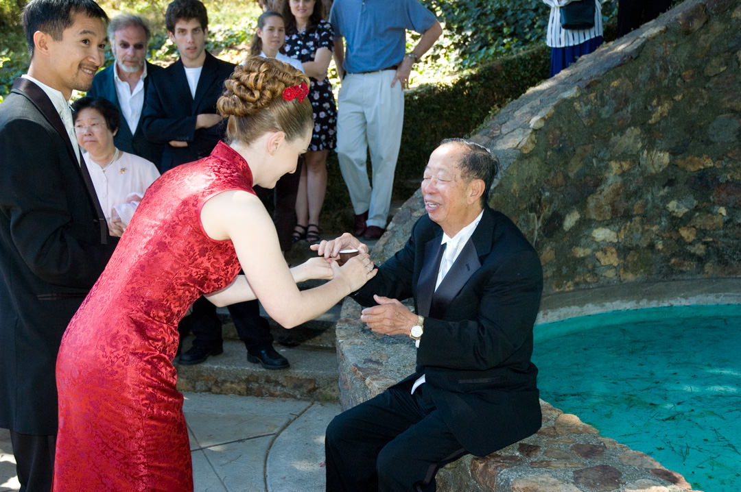 Bride extends tea to father for Chinese tea ceremony