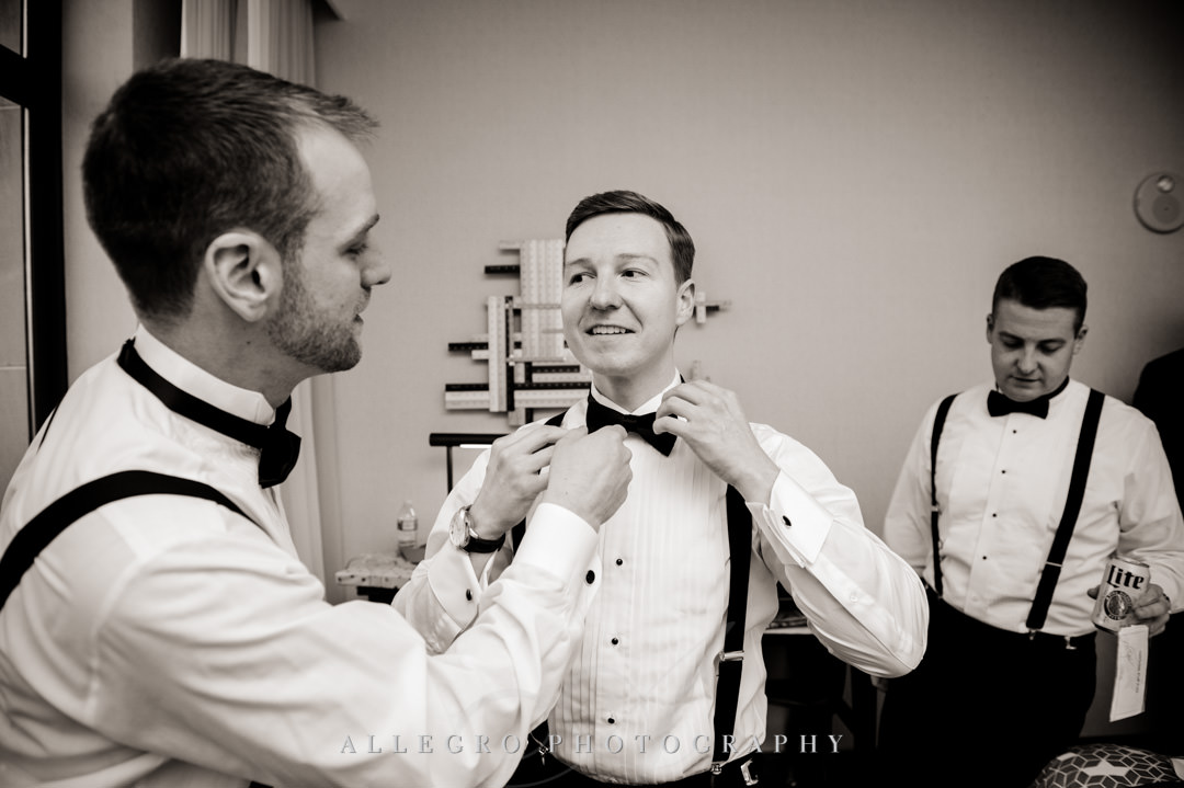 Best man helps groom with his bowtie