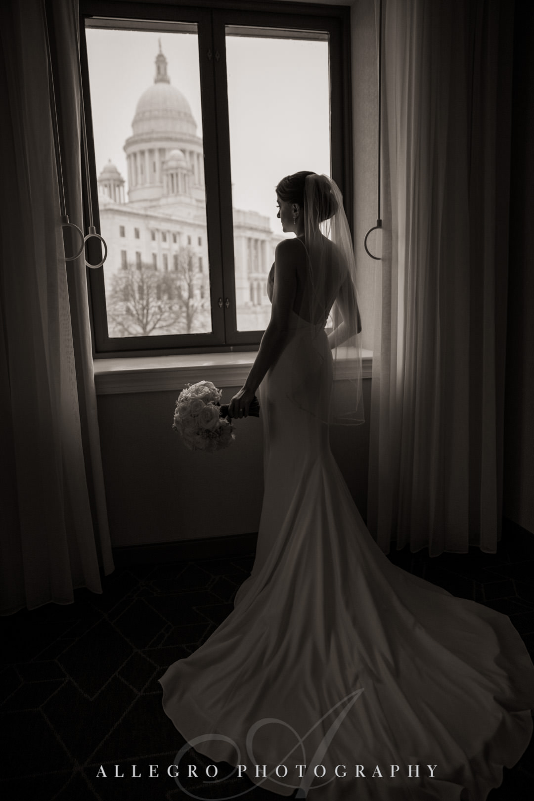 Bride looks outside in her wedding dress- providence state house
