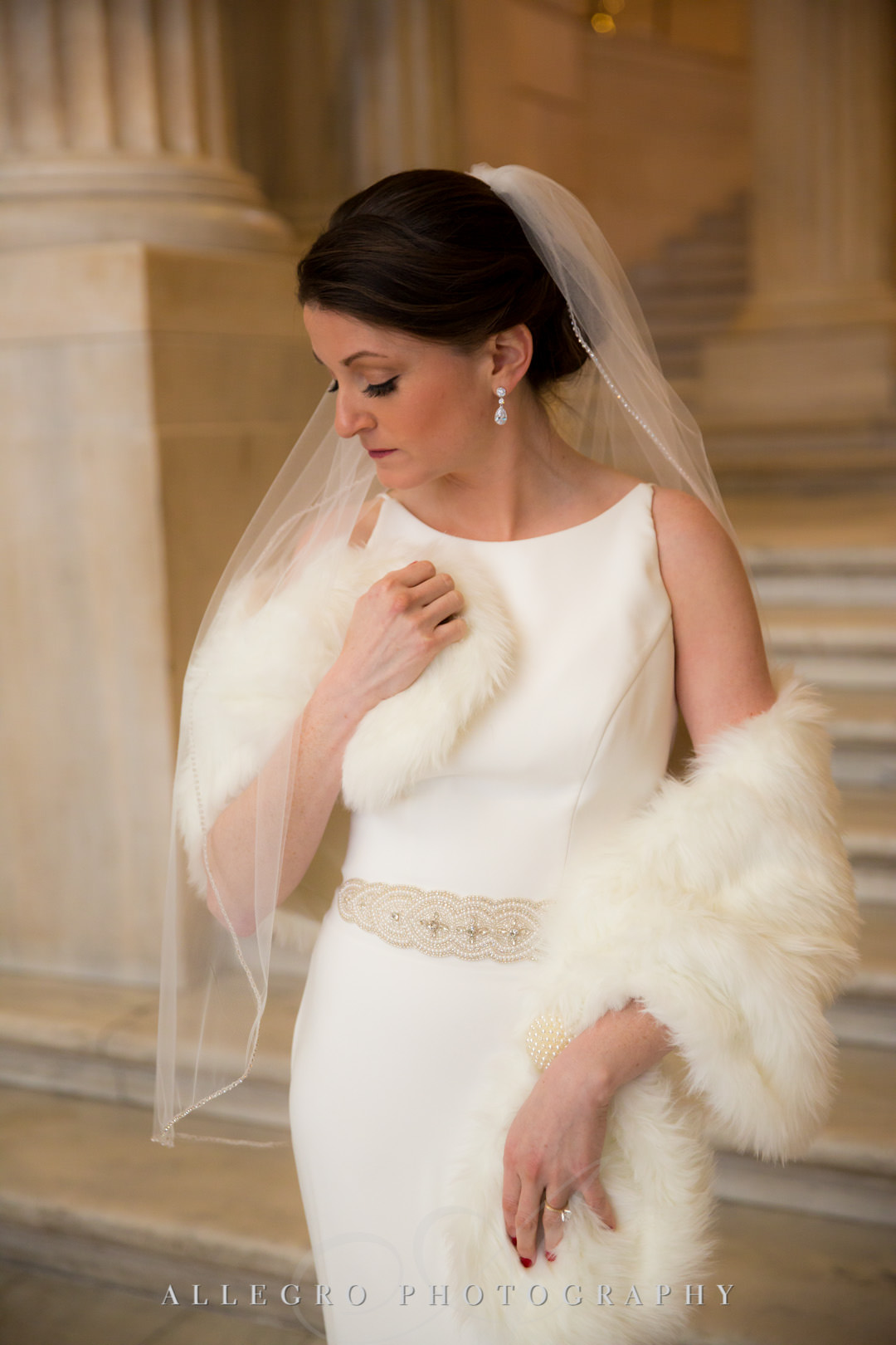 Bride poses with her fur throw in Mikaella bridal gown