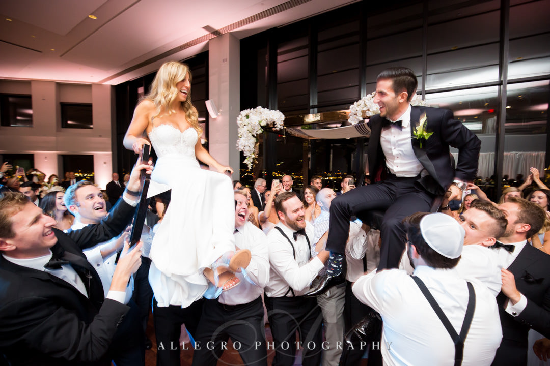 Bride and groom are lifted up in the hora