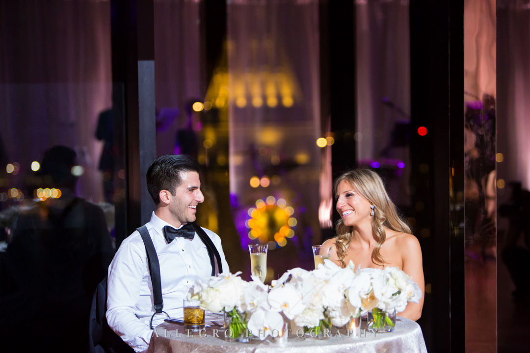 Bride and groom sit at wedding table