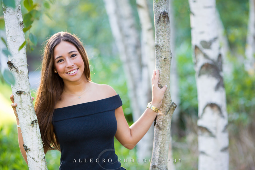 Senior in high school girl posing by a tree
