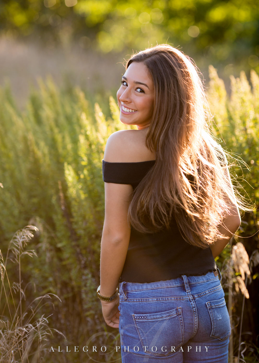 Girl smiling over her shoulder for senior portrait at Wellesley College