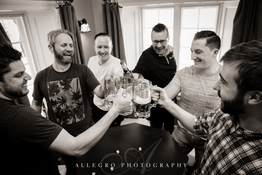 Group of adult men clink beer glasses