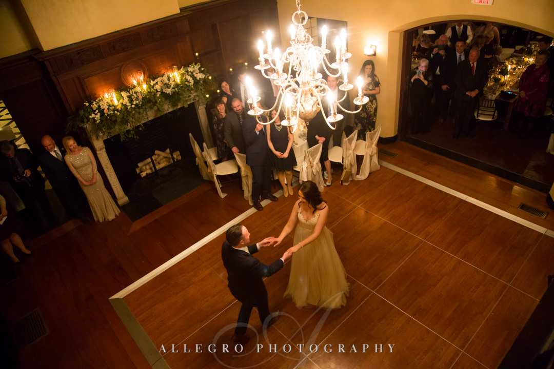 Bride and groom dance under chandelier at wedding reception