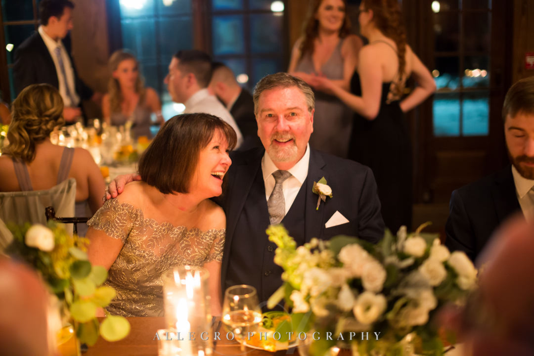 Parents of the groom smile at their son's wedding