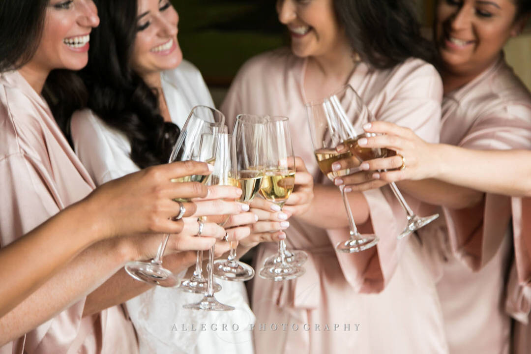 bride and bridesmaids cheers with champagne