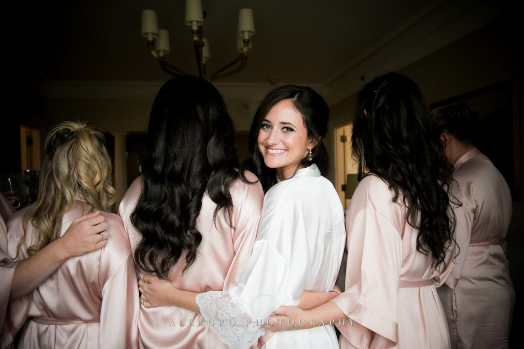 bride smiles as she hugs her bridesmaids