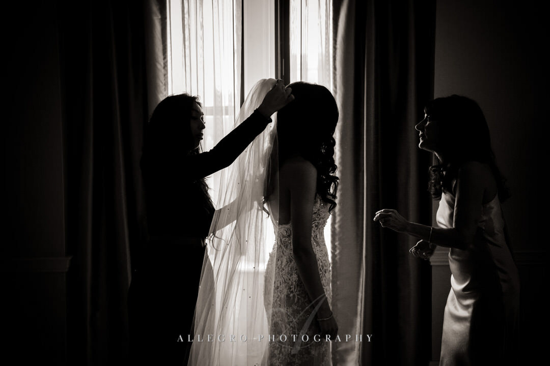 mother of the bride helps bride with veil