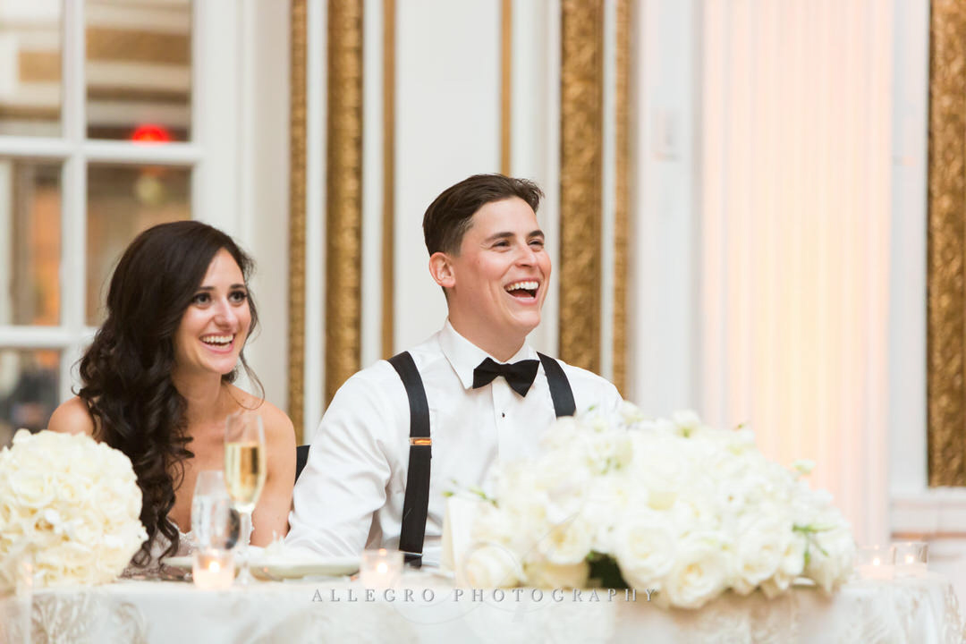bride and groom laugh while they receive toasts