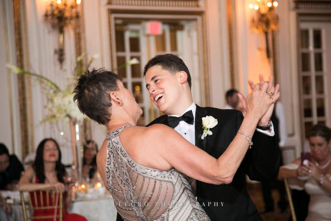 groom smiles as he dances with his mother