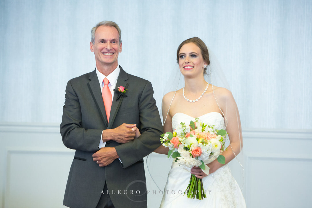 father of the bride smiles as he walks her down the aisle