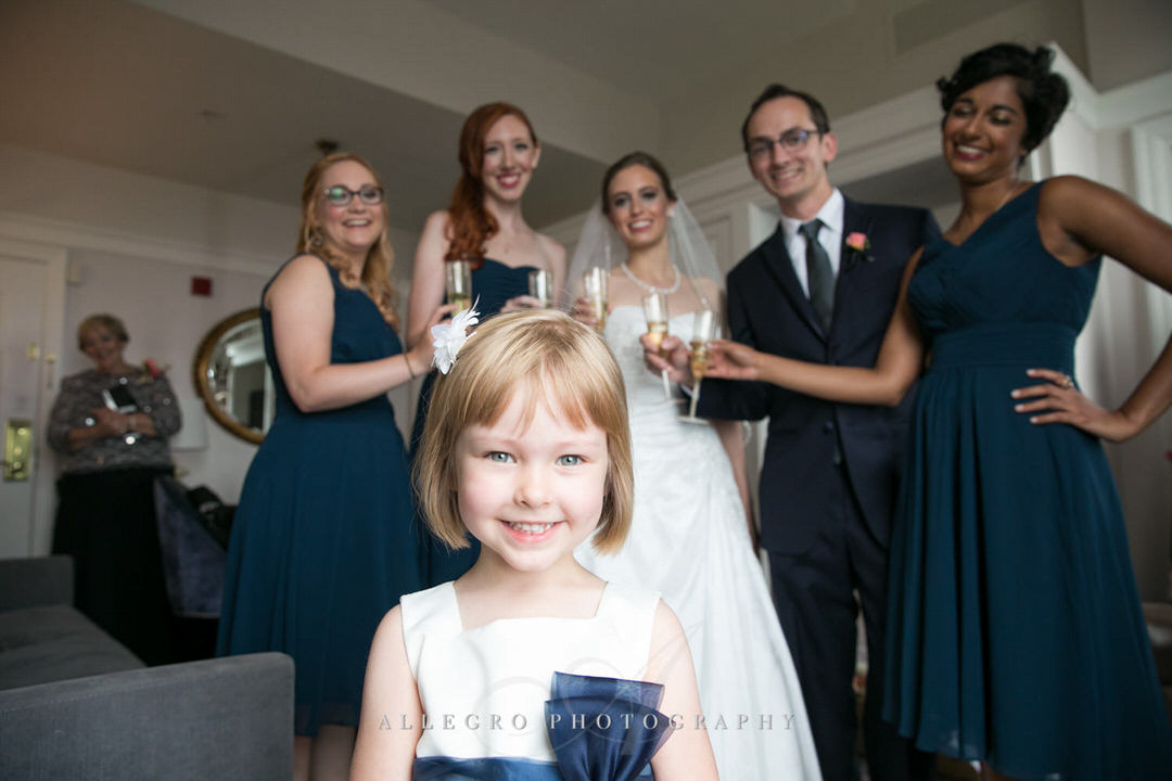 flower girl smiles with bride and bridesmaid in background