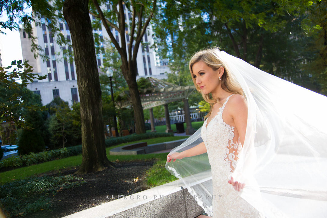 bride with veil blowing in the wind in post office park